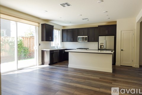 A kitchen with black cabinets and a white island.