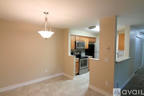 A kitchen with a microwave, oven, and stove top is visible through a glass door.