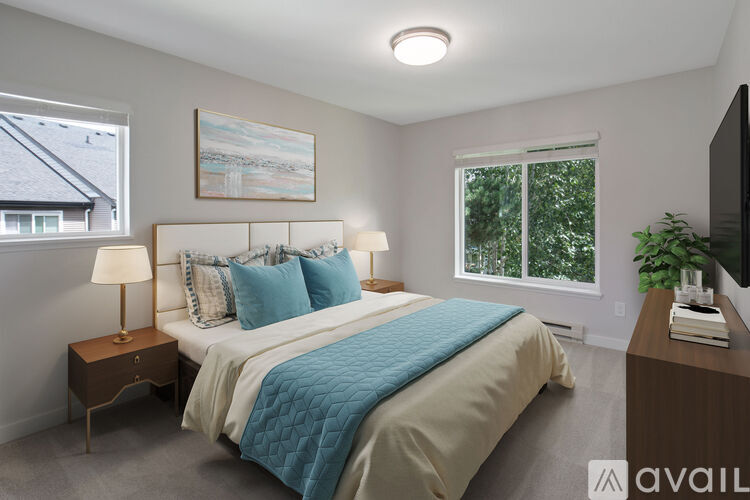 A bedroom with a bed, nightstand, and window.