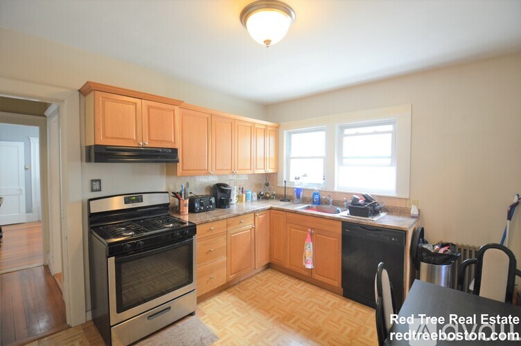 A kitchen with wooden cabinets and a black stove top oven.