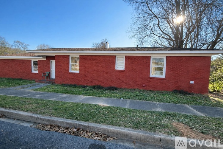 A red brick house with a white door and windows.