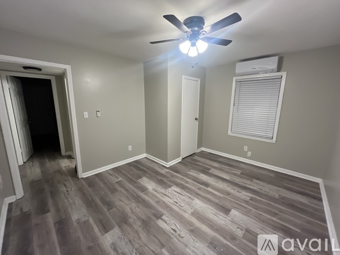 A room with a ceiling fan and wooden flooring.
