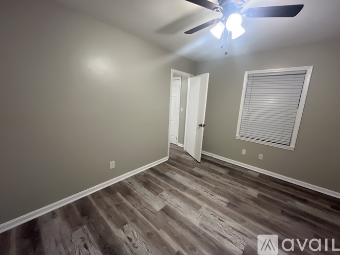A room with a ceiling fan and a door.