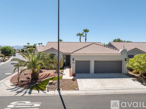 A house with a red tile roof and a palm tree in front.