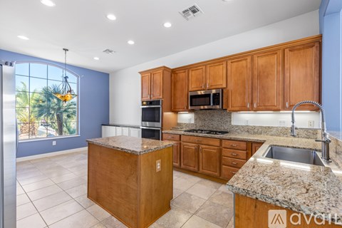 A kitchen with wooden cabinets and granite countertops.