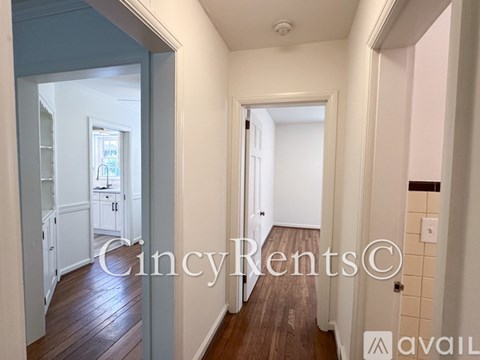 A hallway with a wooden floor and white walls.