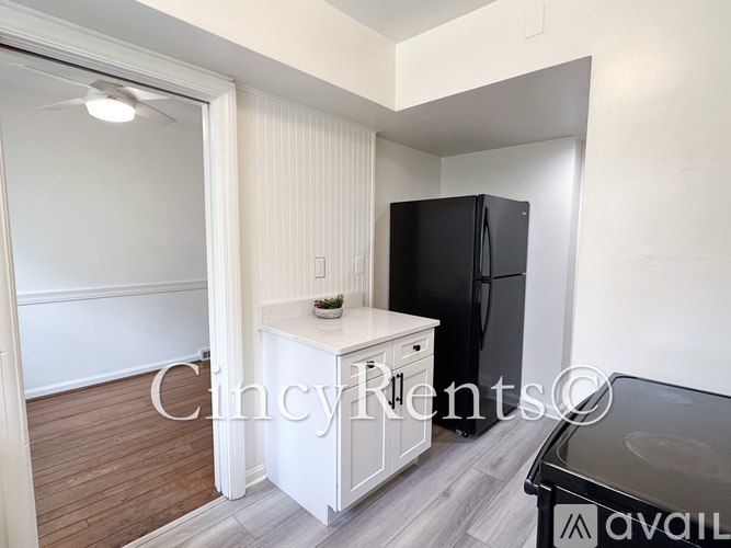 A kitchen area with a black refrigerator and a white countertop.