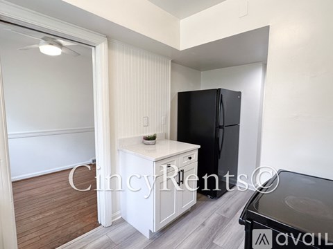 A kitchen area with a black refrigerator and a white countertop.