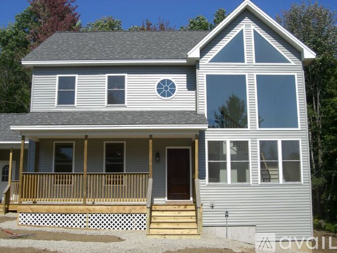 A house with a grey exterior and a brown porch.