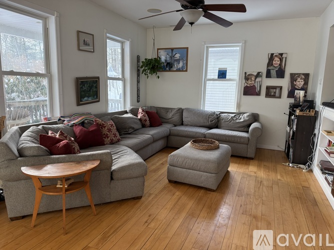 A living room with a grey couch and a wooden table.