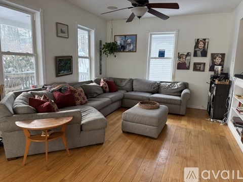 A living room with a grey couch and a wooden table.