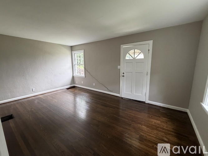 A room with wooden floors and a white door.