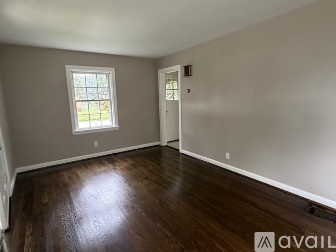 A room with a window and wooden flooring is available for rent.