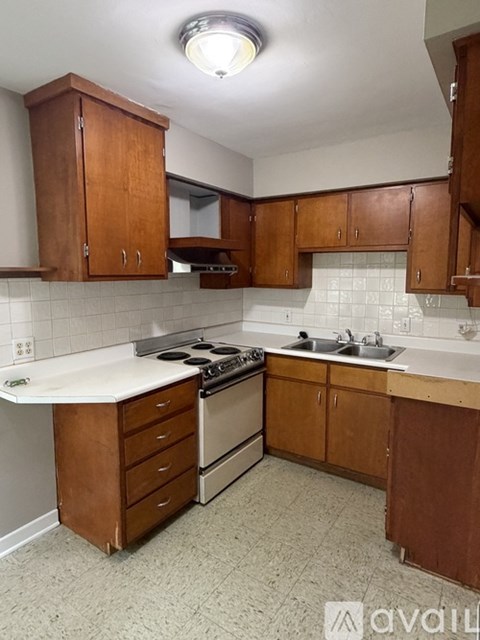 A kitchen with wooden cabinets and a white countertop.