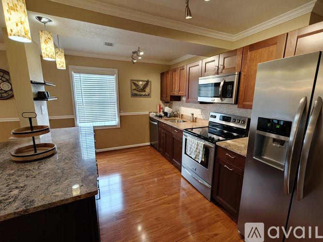 A kitchen with a granite counter top and stainless steel appliances.