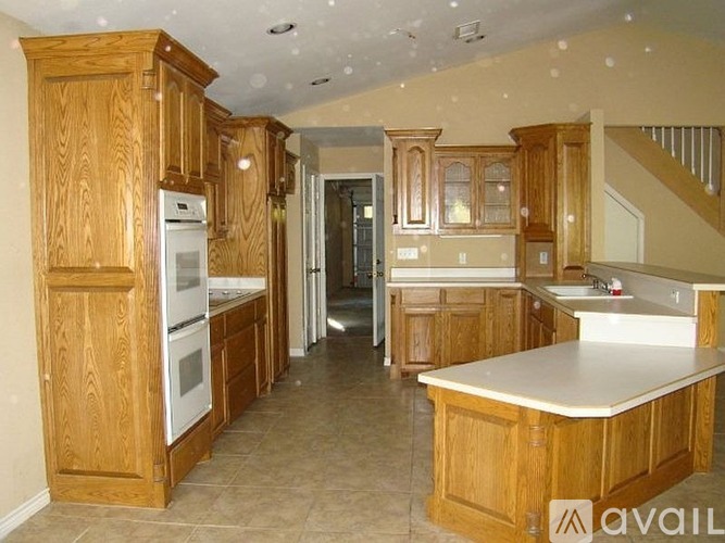 A kitchen with wooden cabinets and a white counter top.