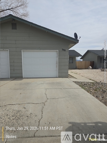 A house with a grey garage door and a white door.