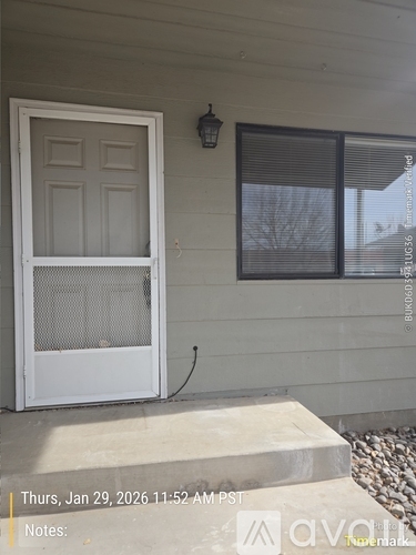 A white door with a screen is on the left and a window with blinds is on the right.
