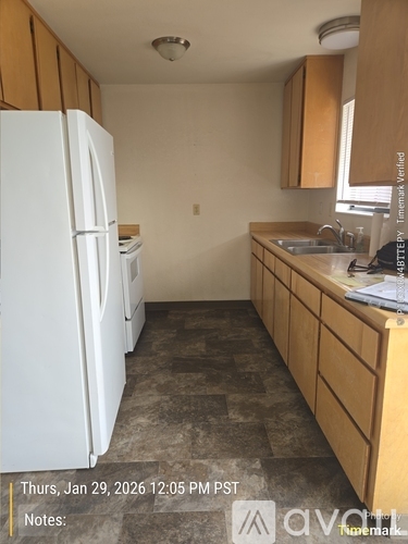 A kitchen with a white refrigerator and wooden cabinets.