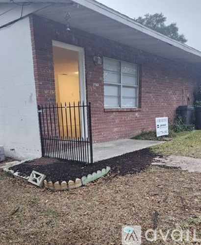 A small house with a white door and a sign in front.