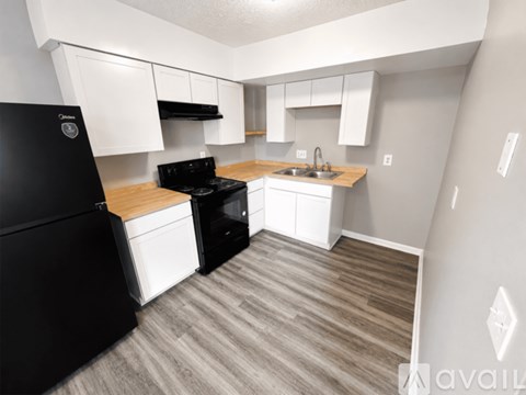A kitchen with black appliances and white cabinets.