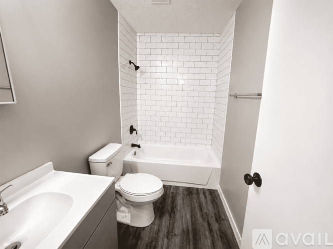 A white bathroom with a toilet, sink, and bathtub.