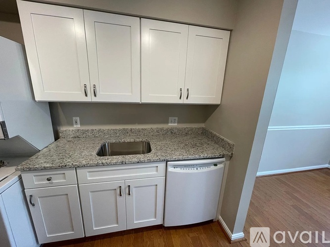 A kitchen with granite countertops and white cabinets.