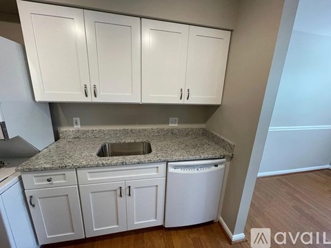 A kitchen with granite countertops and white cabinets.