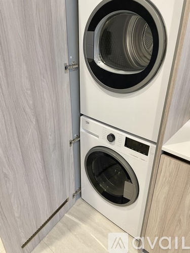 A white washing machine is built into a cabinet.