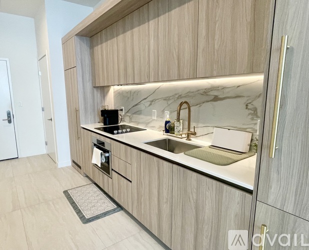 A modern kitchen with wooden cabinets and marble countertops.