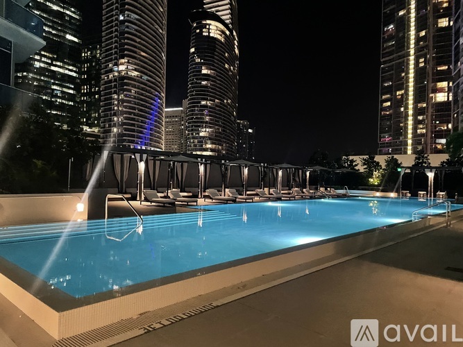 A swimming pool with a cityscape at night.