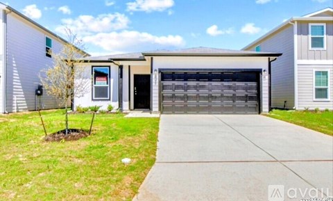 A two-story house with a garage door and a driveway.