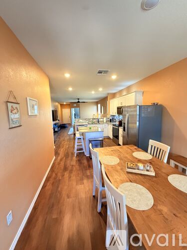 A kitchen with a dining table and chairs in the foreground.