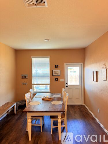 A dining room with a wooden table and chairs.
