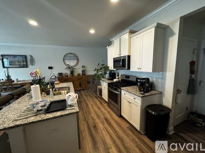A kitchen with wooden floors and a granite countertop.