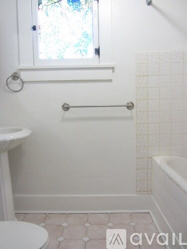 A white toilet sits next to a sink in a small bathroom.