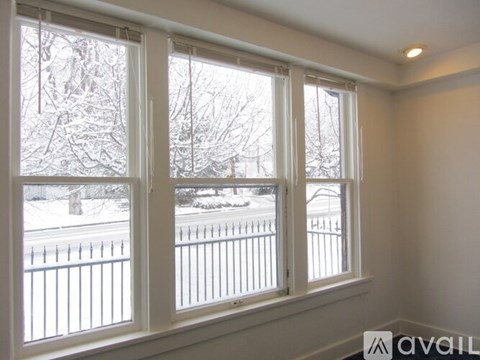 A room with a window showing a snowy landscape outside.