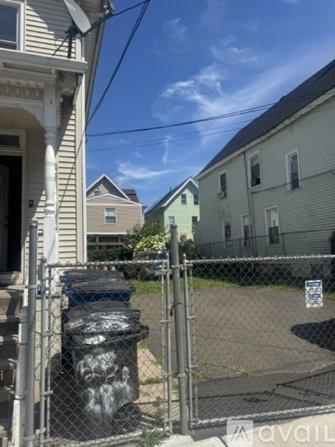 A fenced area with a trash can and a sign.