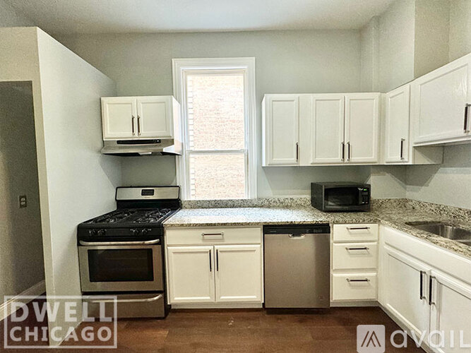 A kitchen with white cabinets and a black stove top oven.