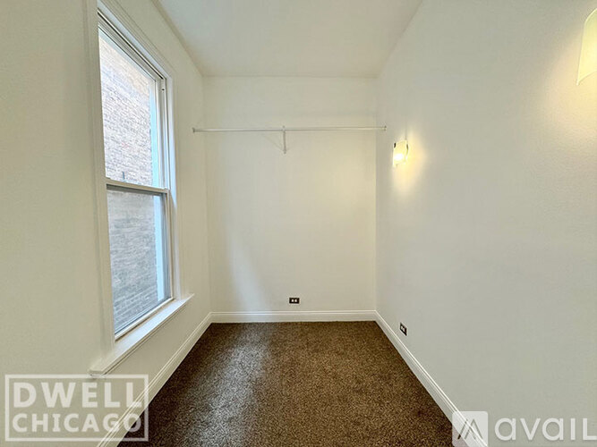 A room with a carpeted floor and a window.