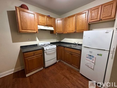 A kitchen with wooden cabinets and a white fridge.