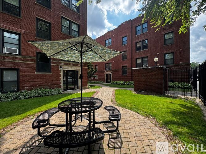 A patio with a table and chairs is surrounded by a brick building.