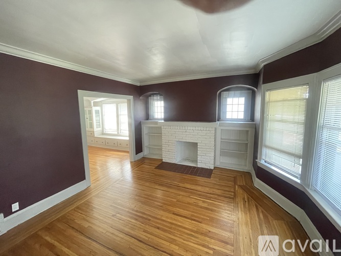 A room with wooden floors and a fireplace.