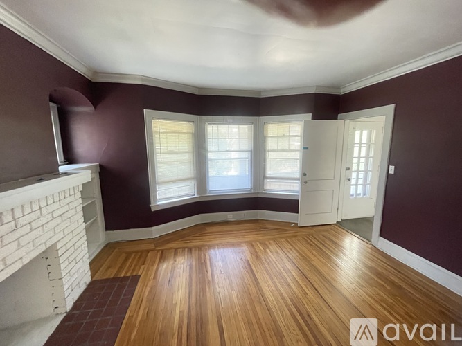 A room with a fireplace and wooden flooring.