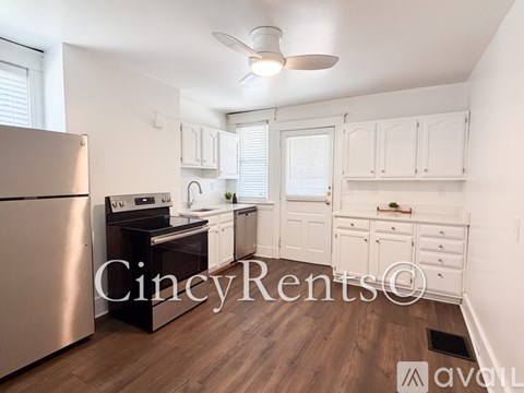 A kitchen with white cabinets and a wooden floor.