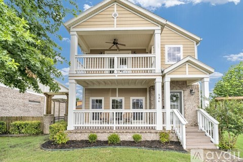 A two-story house with a balcony and a front yard.