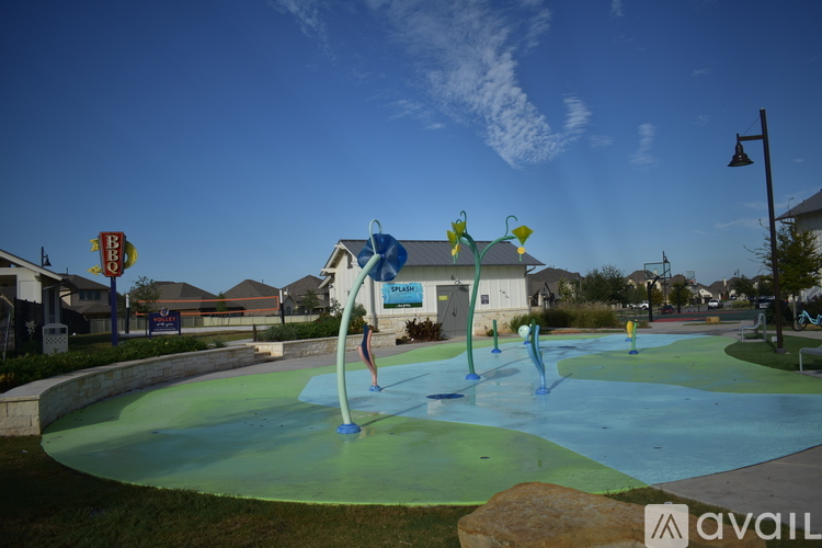 A playground with a blue and green slide and a yellow sign.