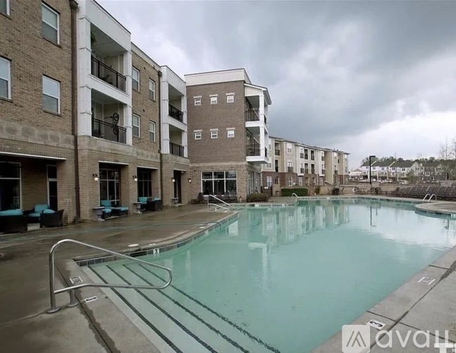 A large swimming pool is surrounded by apartment buildings.