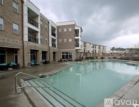 A large swimming pool is surrounded by apartment buildings.