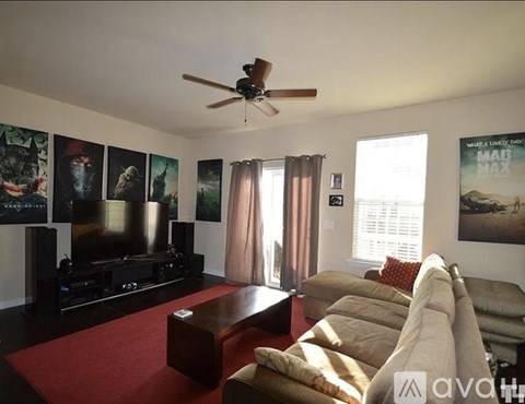 A living room with a red carpet and a brown couch.